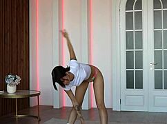 Naked gymnast performs flexible yoga workout in sport.