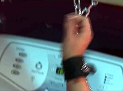 a guy dominates a busty blonde who is chained up in the bathroom